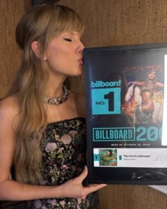 Taylor Swift com uma placa comemorativa do álbum "The Life Of A Showgirl". Imagem: Reprodução.